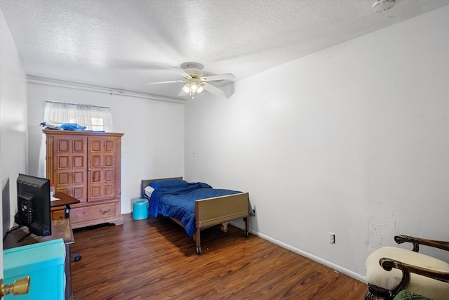 bedroom with a textured ceiling, ceiling fan, and dark wood-type flooring