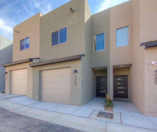 pueblo revival-style home featuring a garage