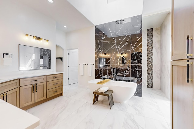 bathroom featuring a washtub, vanity, and tile walls