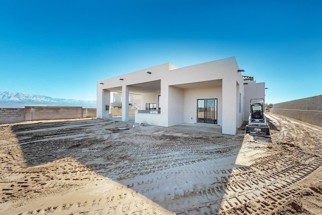 rear view of house featuring a mountain view and a patio area