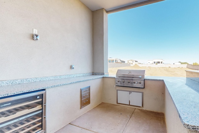 view of patio with area for grilling, a balcony, and wine cooler