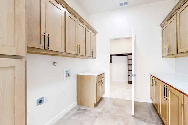 laundry area with hookup for an electric dryer, cabinets, light tile patterned floors, and hookup for a washing machine