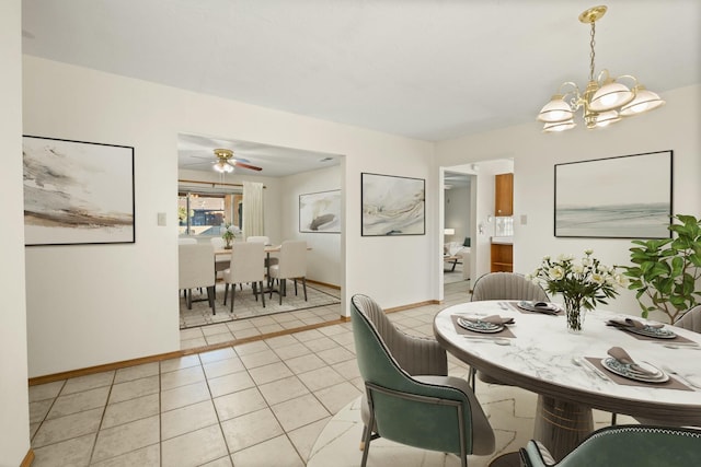 tiled dining area with ceiling fan with notable chandelier