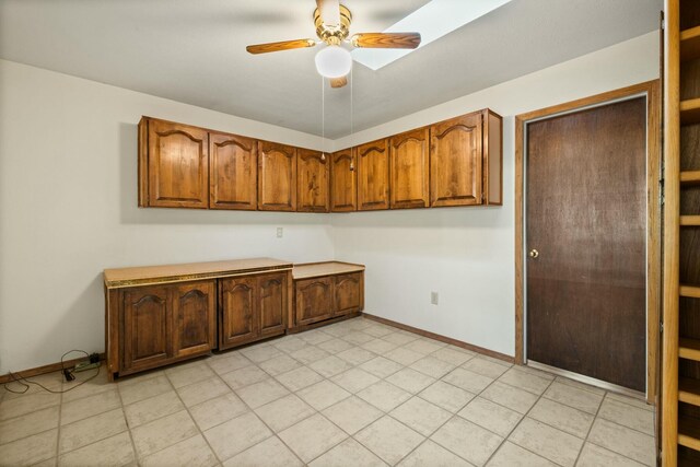 kitchen featuring backsplash, ceiling fan, sink, light tile patterned floors, and dishwasher