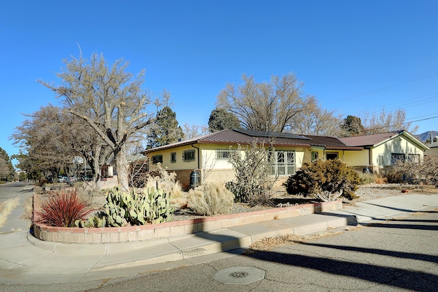 view of front of property featuring solar panels