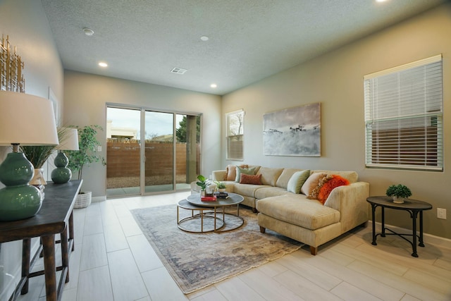 living room with a textured ceiling and light hardwood / wood-style flooring