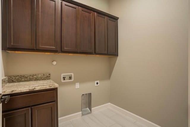 clothes washing area with cabinets, hookup for a washing machine, and hookup for an electric dryer