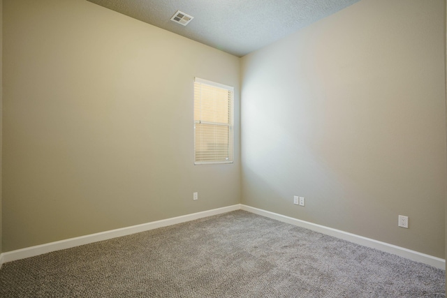 carpeted spare room featuring a textured ceiling