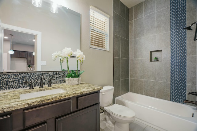 full bathroom with backsplash, vanity, tile patterned flooring, toilet, and tiled shower / bath