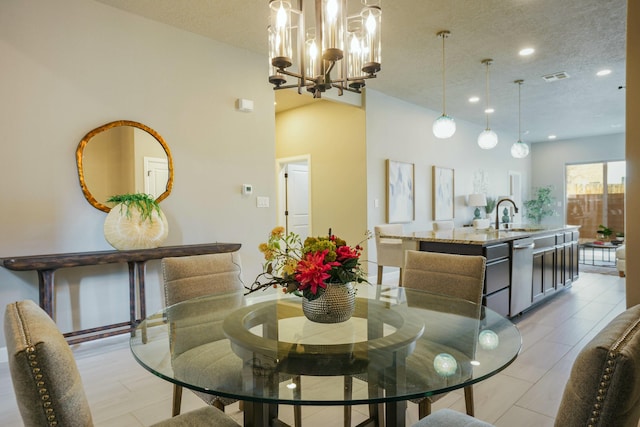 dining room with sink, a textured ceiling, and a notable chandelier