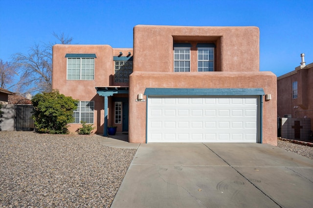 pueblo revival-style home with a garage