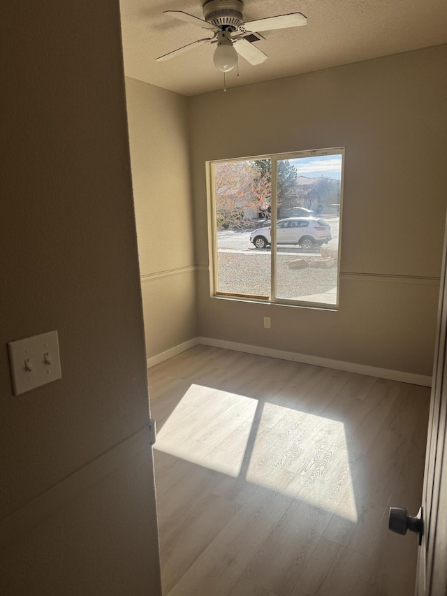 spare room with light hardwood / wood-style flooring and ceiling fan