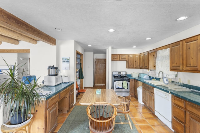 kitchen with white appliances, a textured ceiling, sink, light tile patterned floors, and beamed ceiling