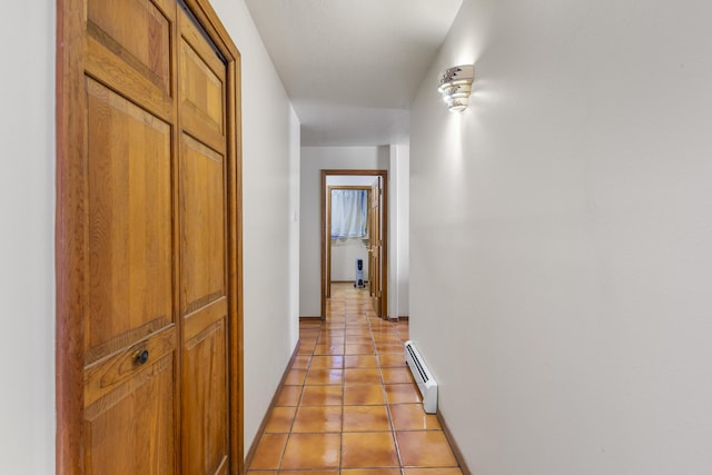 hall featuring light tile patterned floors and a baseboard heating unit