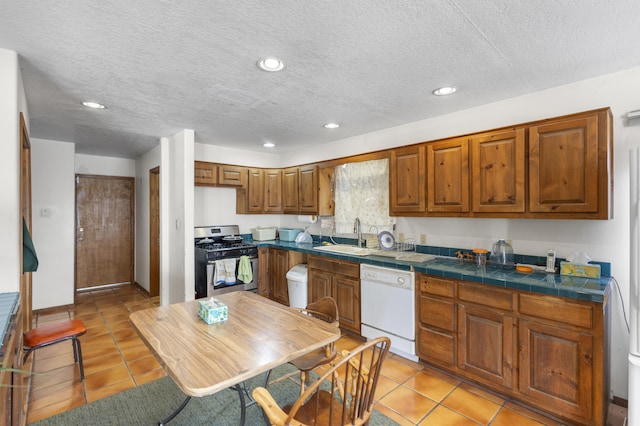 kitchen featuring stainless steel gas range, a textured ceiling, white dishwasher, sink, and light tile patterned floors