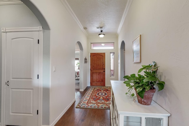 entryway with dark hardwood / wood-style flooring, a textured ceiling, and ornamental molding