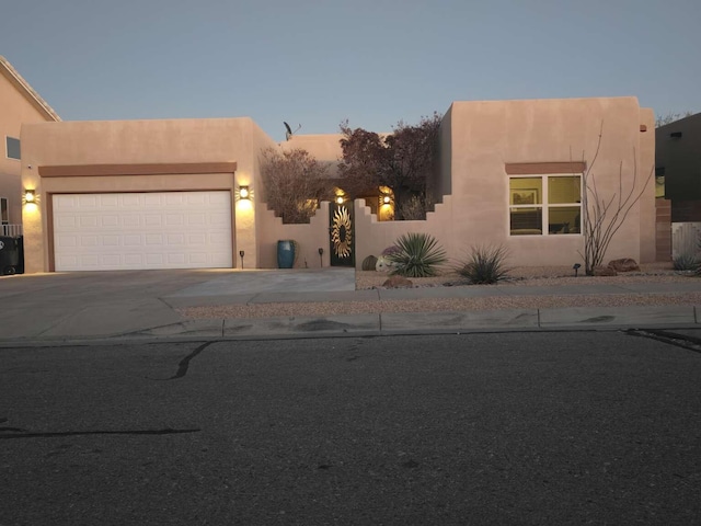 pueblo-style home featuring a garage