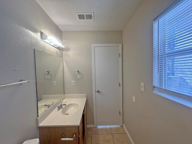 bathroom featuring tile patterned floors, vanity, and a textured ceiling