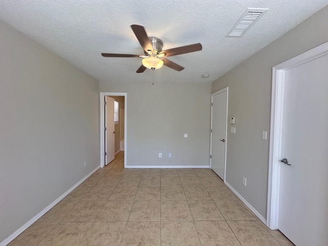 spare room with light tile patterned floors, a textured ceiling, and ceiling fan