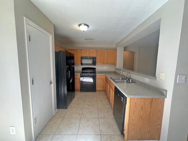 kitchen featuring sink, light tile patterned flooring, black appliances, and a textured ceiling