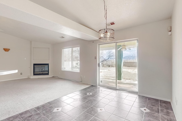 unfurnished living room featuring carpet floors, a textured ceiling, and a notable chandelier