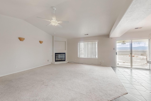 unfurnished living room with light colored carpet, vaulted ceiling, and ceiling fan