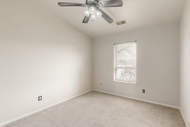 spare room with light carpet, vaulted ceiling, and ceiling fan