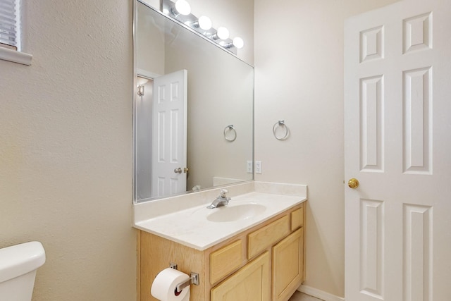 bathroom featuring vanity and toilet