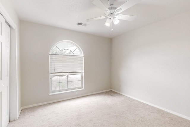 carpeted spare room featuring ceiling fan