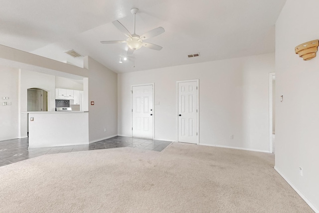 unfurnished living room with ceiling fan, carpet floors, and vaulted ceiling