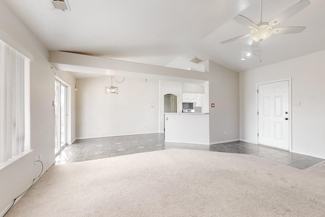 unfurnished living room with vaulted ceiling, carpet floors, and ceiling fan with notable chandelier