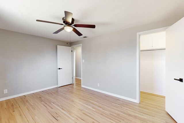 unfurnished bedroom with ceiling fan, light hardwood / wood-style floors, and a closet