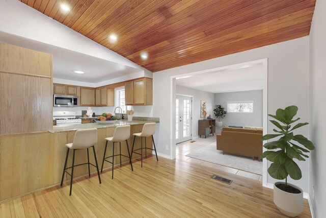 kitchen with white gas stove, kitchen peninsula, wood ceiling, and light hardwood / wood-style flooring