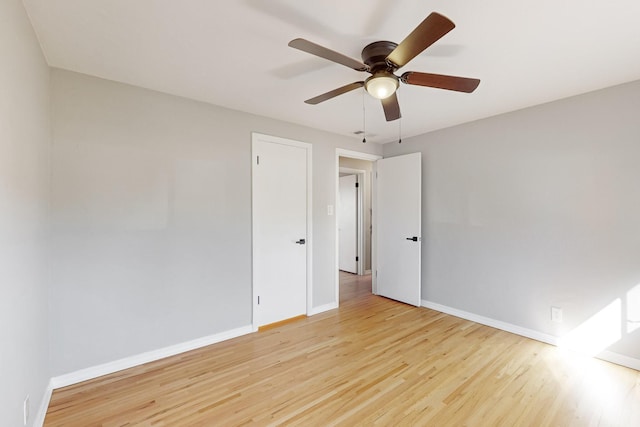 spare room with ceiling fan, wood finished floors, and baseboards