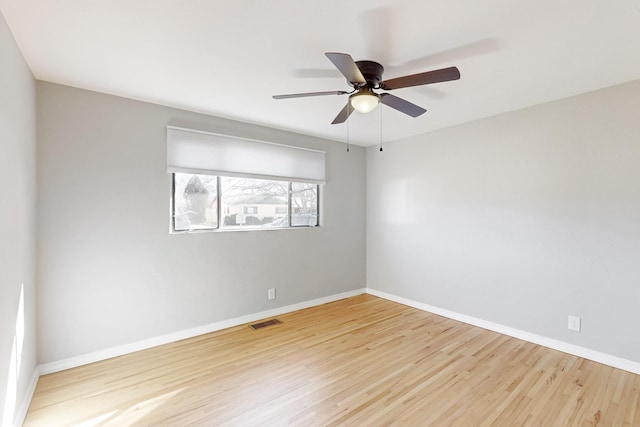 unfurnished room featuring visible vents, baseboards, and wood finished floors