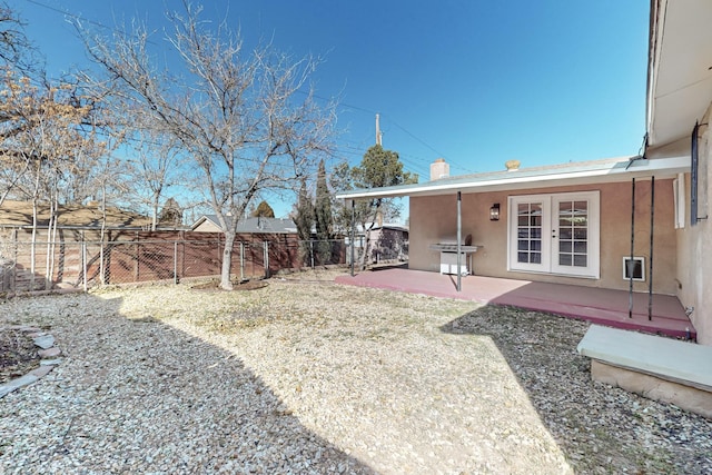 view of yard featuring a fenced backyard, a patio, and french doors