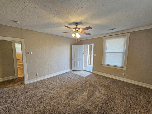 carpeted spare room featuring a textured ceiling and ceiling fan