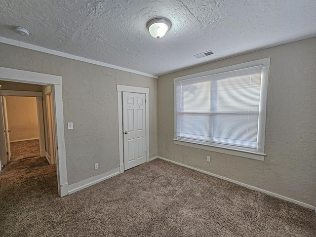 unfurnished bedroom featuring carpet flooring, a textured ceiling, and a closet