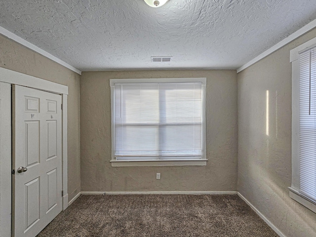 interior space featuring dark carpet and a textured ceiling