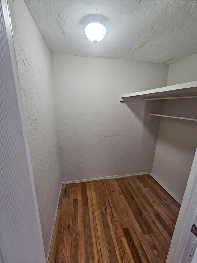 spacious closet with dark hardwood / wood-style flooring