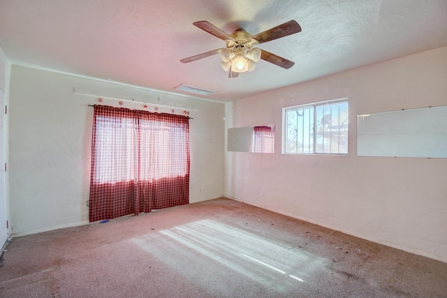 carpeted empty room featuring ceiling fan and a textured ceiling