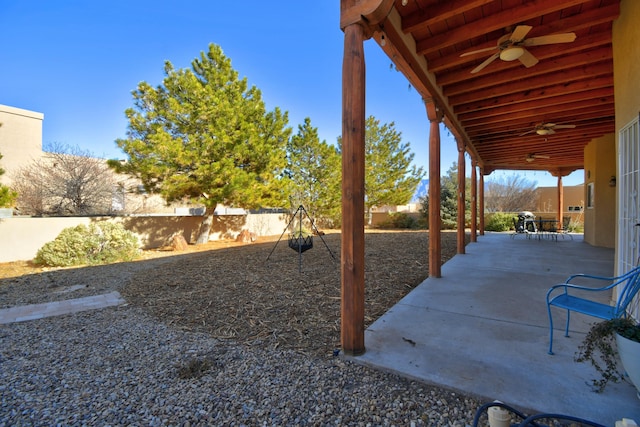 view of yard featuring ceiling fan and a patio