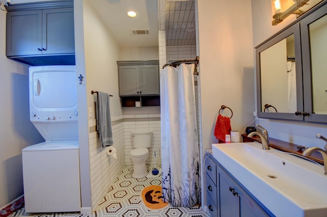 bathroom with vanity, tile patterned flooring, toilet, walk in shower, and stacked washer / drying machine