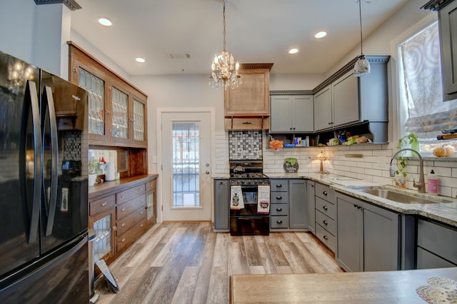 kitchen with light hardwood / wood-style floors, sink, black appliances, pendant lighting, and gray cabinets