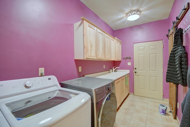 clothes washing area featuring washer and clothes dryer, light tile patterned flooring, cabinets, and sink