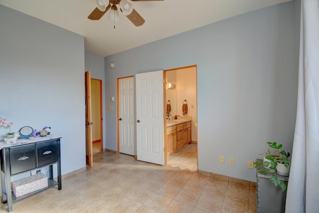 tiled bedroom featuring ceiling fan and connected bathroom