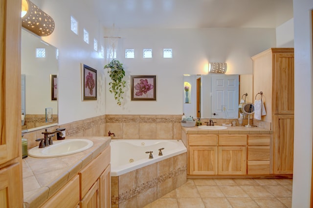 bathroom featuring tile patterned floors, tiled bath, and vanity