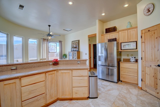 kitchen featuring stainless steel refrigerator with ice dispenser, light tile patterned floors, ceiling fan, and light brown cabinetry