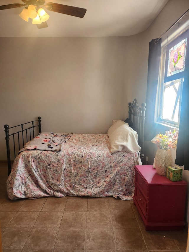 bedroom with ceiling fan and dark tile patterned floors