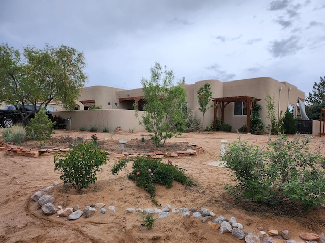 pueblo revival-style home featuring a pergola